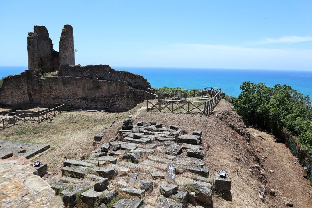 I resti della torre angioina e i blocchi del santuario sull'Acropoli di Velia, con il mare sullo sfondo